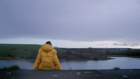 lonely man in yellow jacket sitting in nature and thinks about life