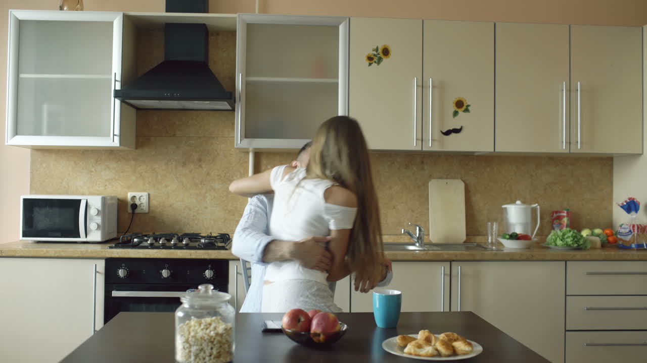 Coppia che si bacia in cucina