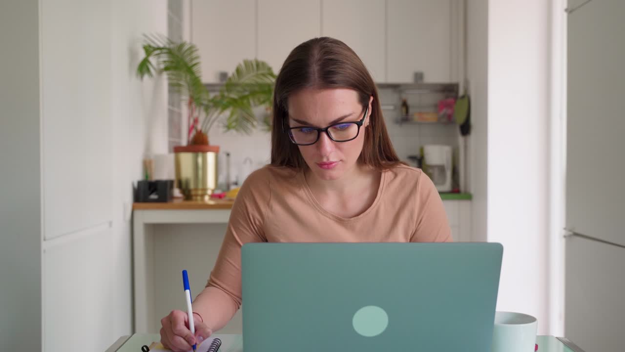 Young female millennial working on laptop at home office