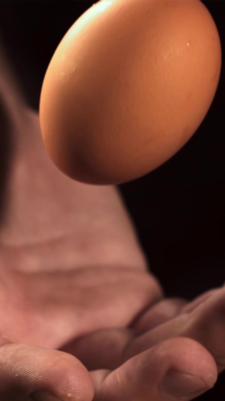 Slow Motion Close-up of a Hand Levitating a Brown Egg