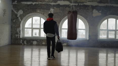 Y-Un-Atleta-Entrando-A-La-Habitación-Con-Una-Bolsa,-Listo-Para-Comenzar-A-Entrenar