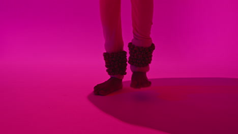 Close-Up-On-Feet-And-Bells-Of-Female-Kathak-Dancer-Performing-Dance-Wearing-Traditional-Indian-Dress-Against-Purple-Background-2