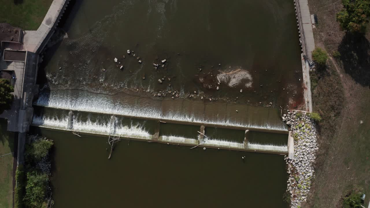Flint River with dam in Flint, Michigan with drone video moving down