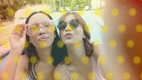 posing for selfie, two women with sunburst animation overlay