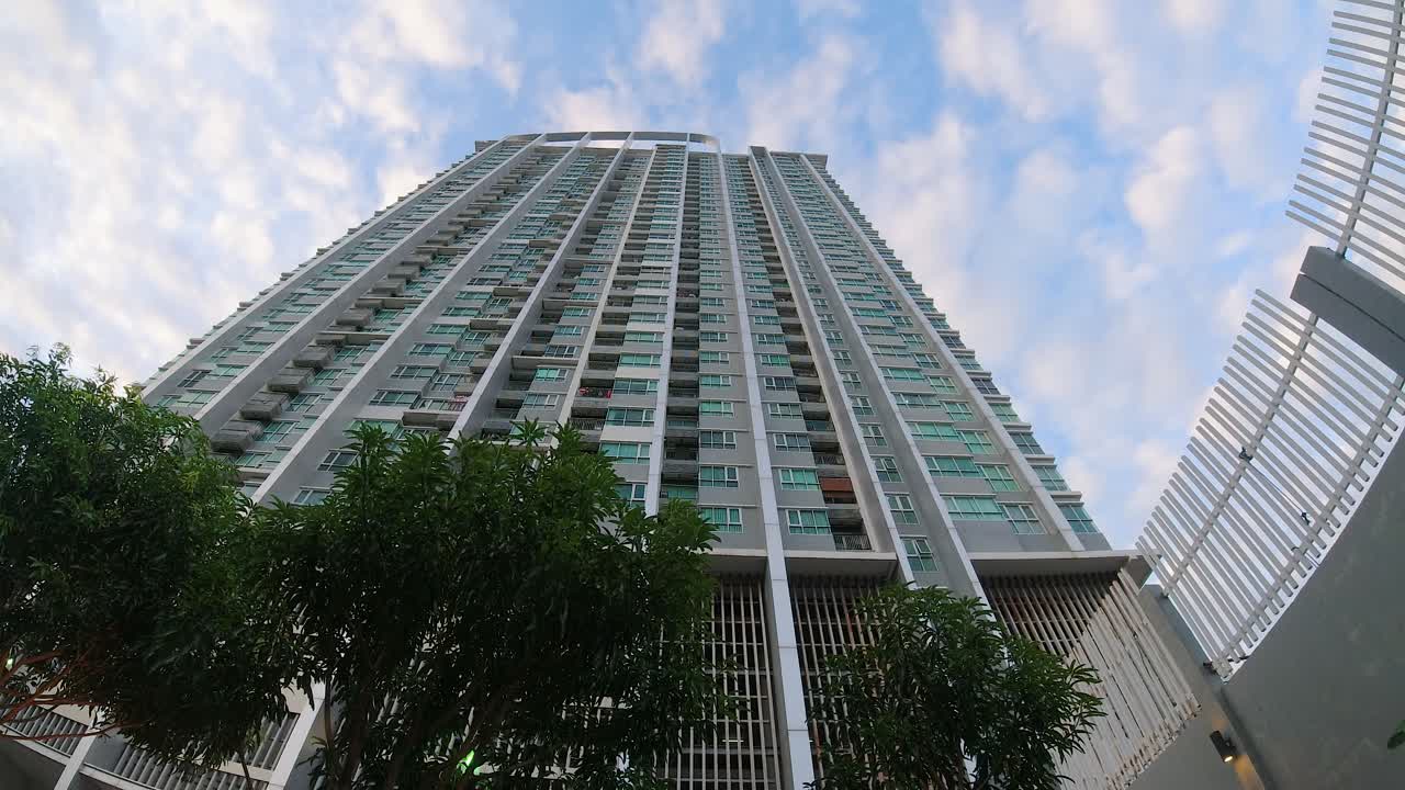 lapso de tiempo de un edificio de condominios mirando directamente hacia arriba con el cielo y las nubes
