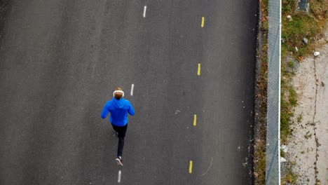 Man-listening-to-music-while-jogging-on-the-street,-4K-4k