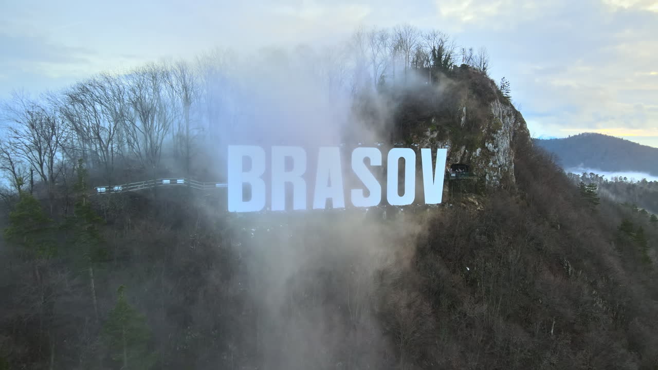 Brasov sign on the top of the hill near the city, bare trees, tourists, low clouds, Romania