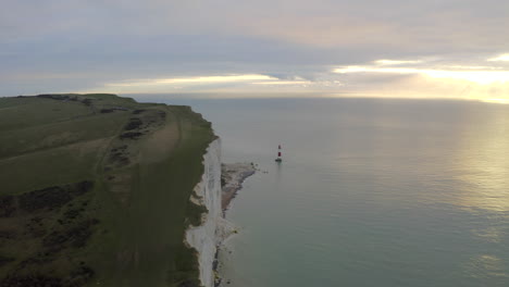 Una-Toma-Aérea-Volando-Junto-Con-Las-Siete-Hermanas-Hacia-El-Faro-De-Beachy-Head-En-La-Costa-Sur-De-Inglaterra,-Con-Enormes-Acantilados-Y-Mar