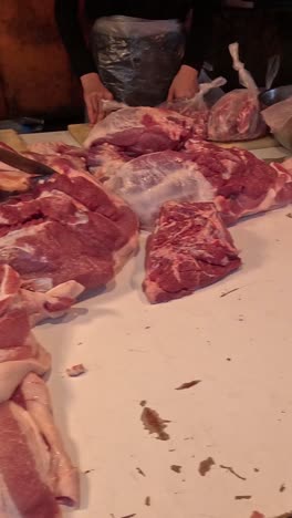 carnicero cortando y arreglando la carne en el mostrador