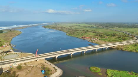 new bridge over river near endless ocean in indonesia, aerial view