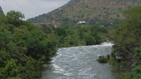 inundación primaveral del río cocodrilo con presa hartbeespoort en la distancia