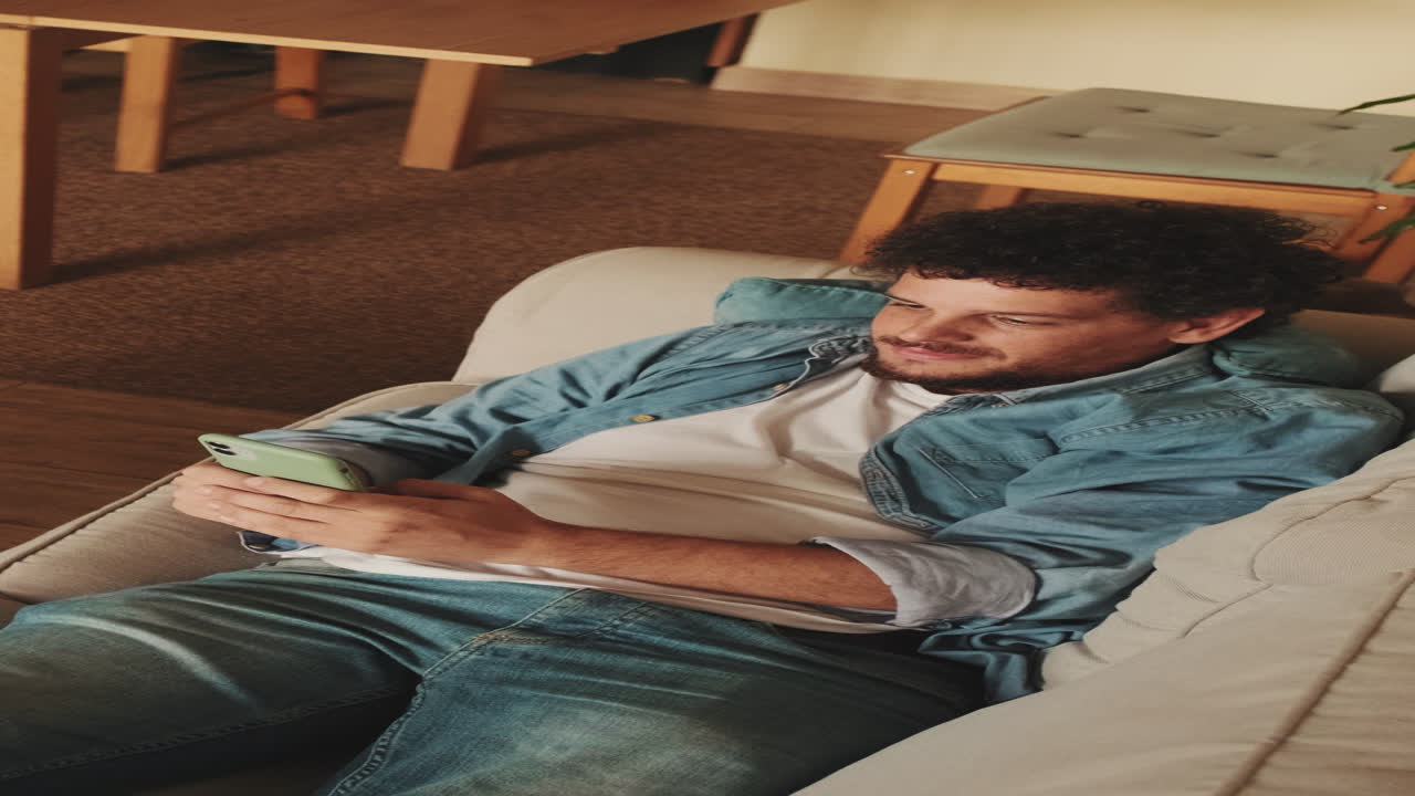 Uomo che usa il telefono sul divano