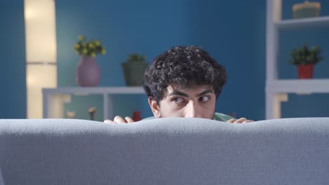 mentally ill schizophrenic man hallucinating at home. young man having irrational doubts and thoughts.