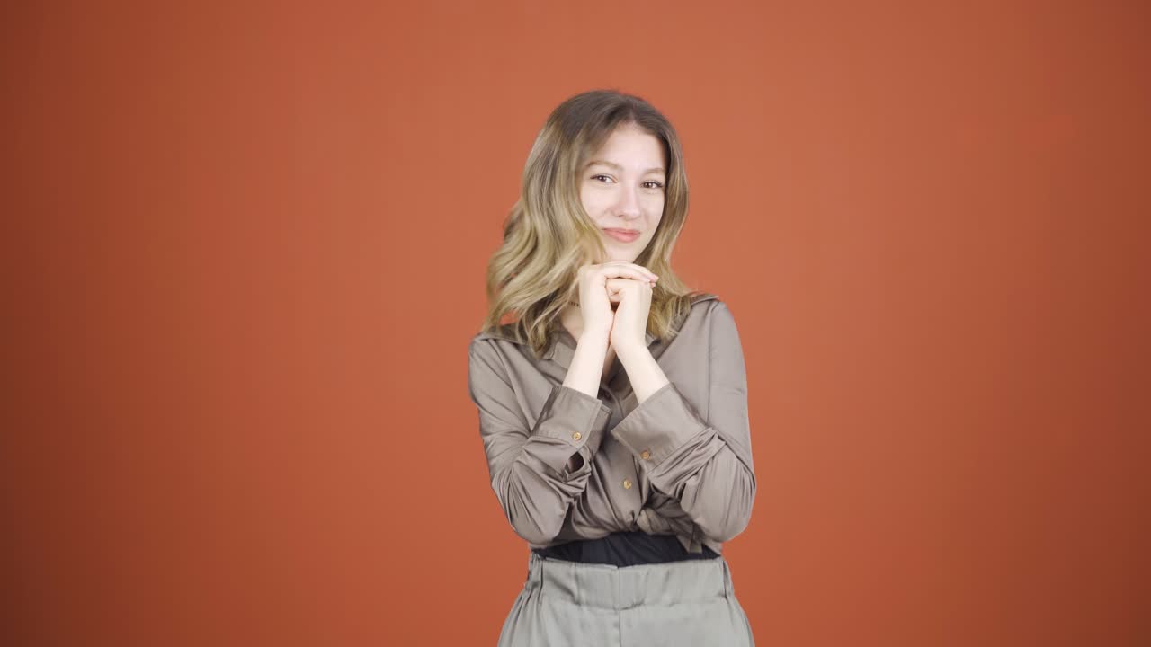 젊은 여성이 카메라에 흥분해서 박수를 치고 있습니다.