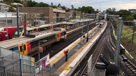 Zug-Am-Bahnsteig-Ab-Bowen-Hills-Station,-Brisbane-Translink-Queensland-Railway,-High-Angle-Handheld-Motion-Shot