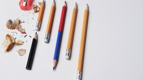 Nahaufnahme-Von-Bleistiften-Und-Bleistiftspitzer-Auf-Weißem-Hintergrund,-In-Zeitlupe