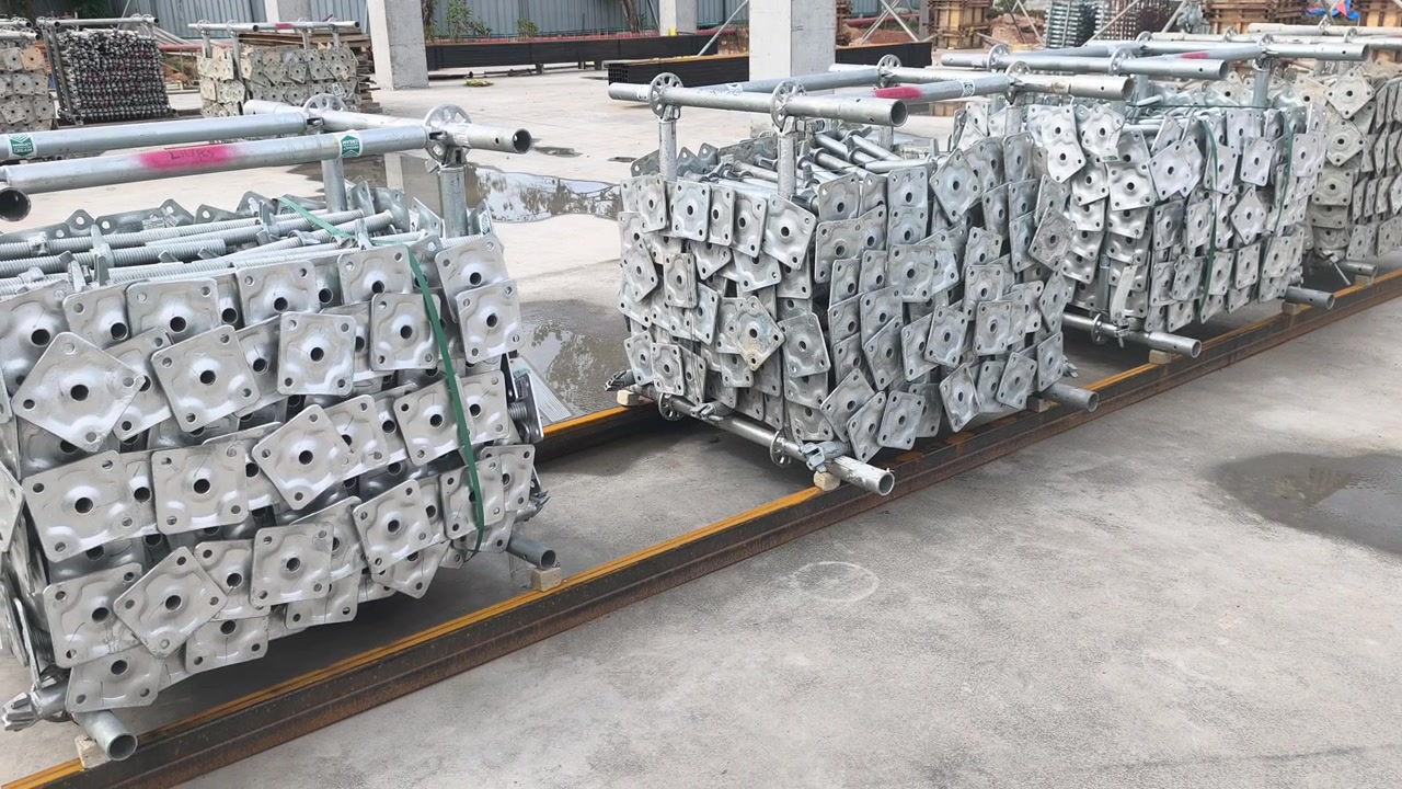 Ponteggi modulari e materiali per casseforme ordinatamente impilati in un cantiere. Sistema modulare in acciaio Ringlock pronto per l'assemblaggio su progetti edilizi. Attrezzatura essenziale di supporto strutturale