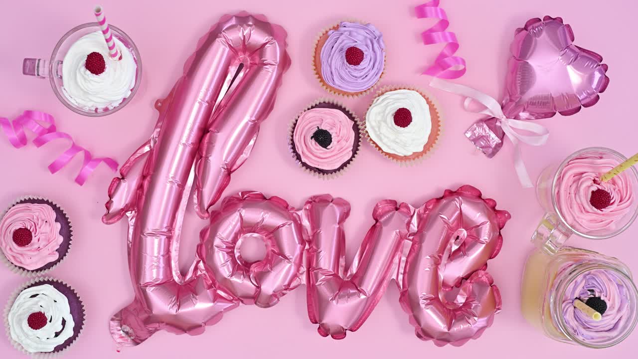 맛있는 컵 케이크는 파스텔 분홍색 테마에서 발렌타인 데이를 위해 사랑의 풍선을 움직입니다.