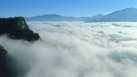 drone overview of an impressive sea of clouds in high mountain with blue sky