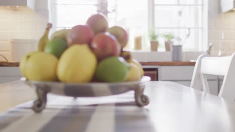 close up of table with fruits in silver bowl in kitchen