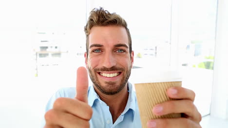businessman getting a coffee and giving thumbs up