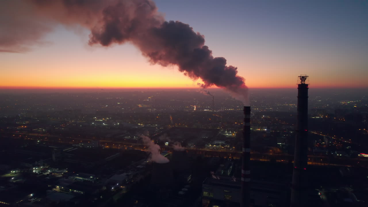 Aerial drone view of thermal power plant in Chisinau at sunset, Moldova. View of pipes with felling steam, cityscape