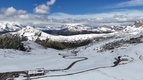 aerial view over passo di giau road winding through snow-covered dolomites near ra gusela peak