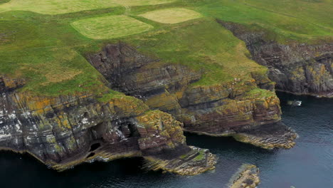 cinematic drone shot of whaligoe haven revealing the rocky 250ft cliffs overlooking the north sea in scotland