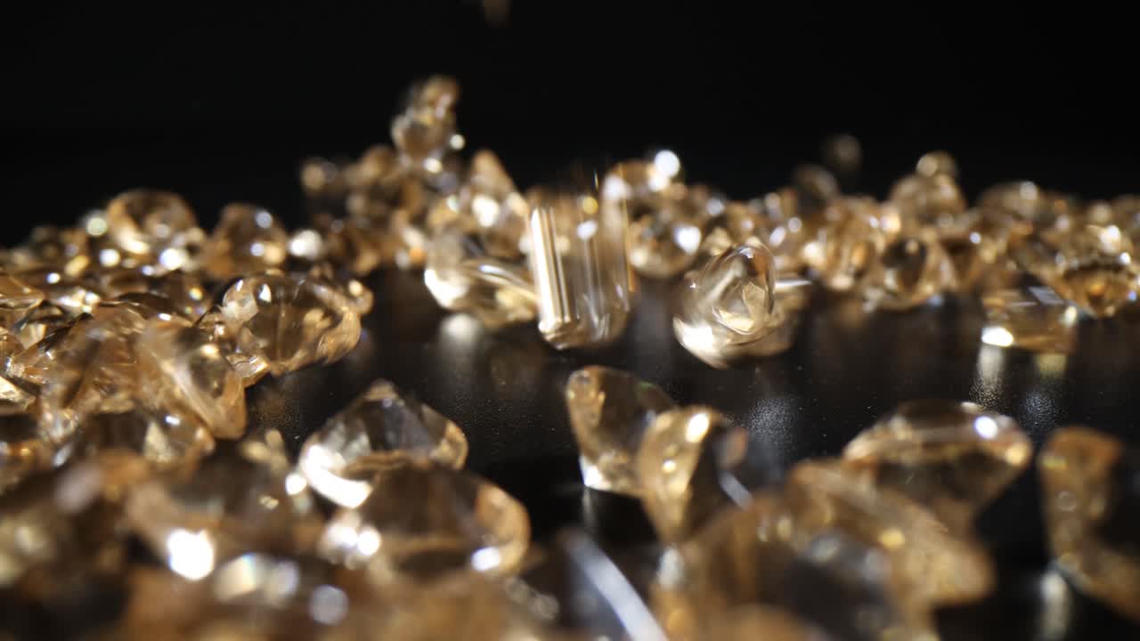 Bright diamonds fall on dark table leaving reflections