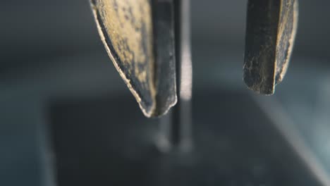 A-close-up-macro-detailed-slow-tilt-up-shot-of-a-spartan-face-design,-warrior-ancient-greek-sign,-bronze-helmet,-on-a-360-rotating-stand,-studio-lighting,-4K-smooth-movement