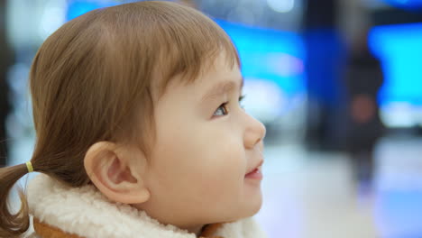 Niña-Feliz-De-3-Años-Que-Disfruta-Jugando-En-El-área-De-Juegos-Mientras-Bebe-Jugo-Dentro-De-Un-Centro-Comercial