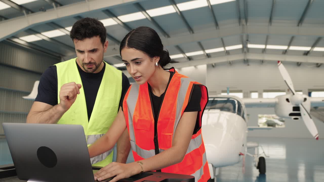 Equipo de mantenimiento de aeronaves inspeccionando un avión con un portátil