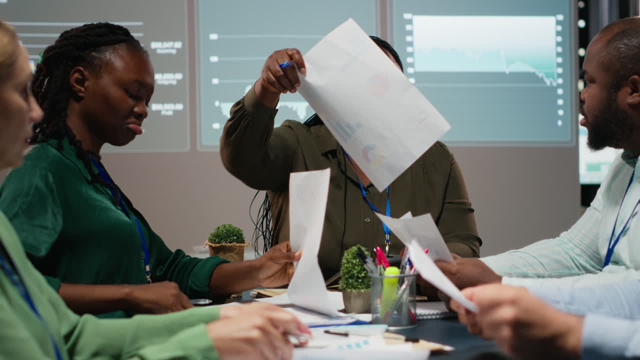 Business partners examining annual sales reports in corporate meeting