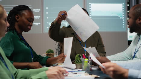 business partners examining annual sales reports in corporate meeting