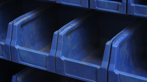 storage of finished metallic parts. worker laying steel blanks in compartment