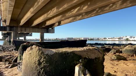 Holzboot-Auf-Dem-Boden-Unter-Der-Brücke,-Aufnahme-Bei-Sonnenschein,-Standort-In-Spanien