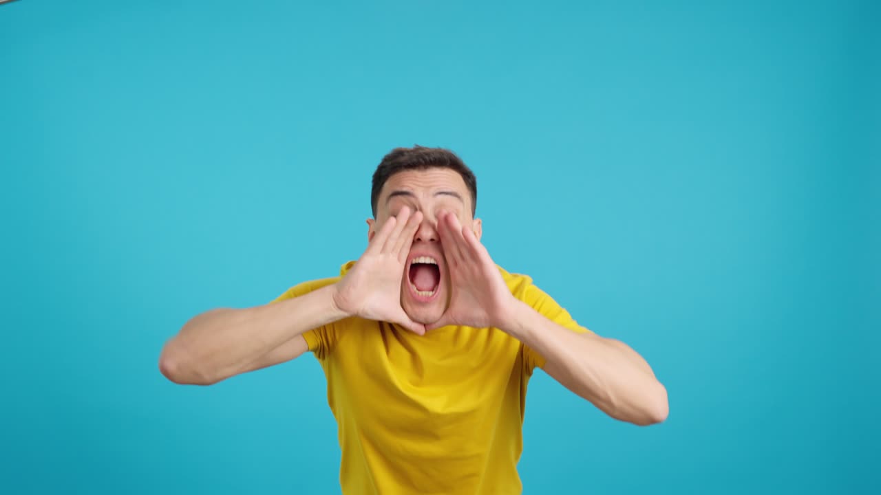 Man in yellow shirt yelling with surprise