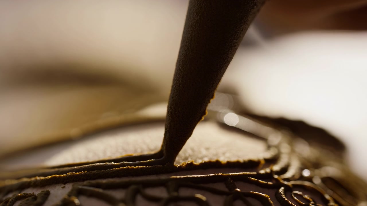 Håndgravering af en ring, i nærbillede af en hånd og smykker, med ring, værktøj, med metallisk ringmateriale, værktøjsmaterialetekstur, fra et makro-nærbillede, med guld, sorte accenter.