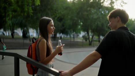 dos jóvenes hablando en un parque de patinaje