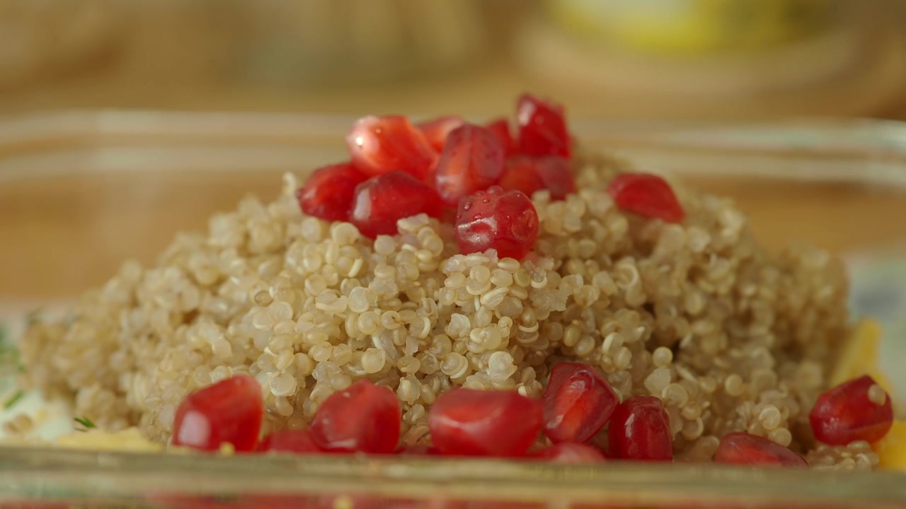 Gros plan sur du quinoa cuit garni de graines de grenade
