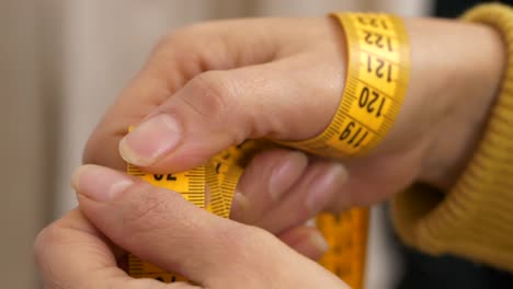 close-up of tape measure in woman hands. slow-motion