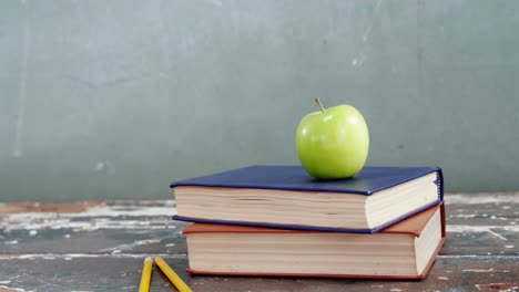 green apple on book stack