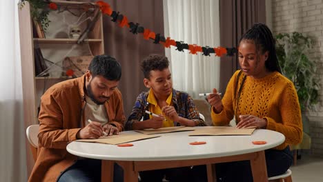 family enjoying halloween crafts and drawing at home