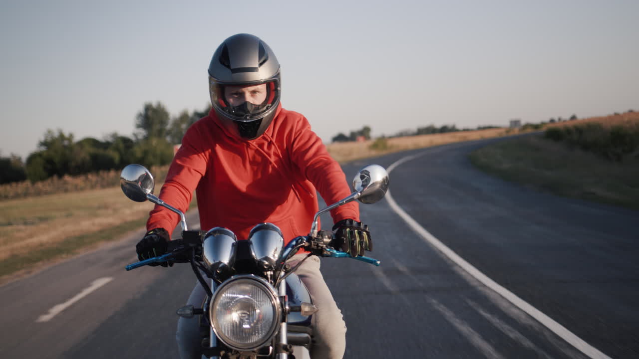 Um jovem de moto pilota por campos pitorescos 3.