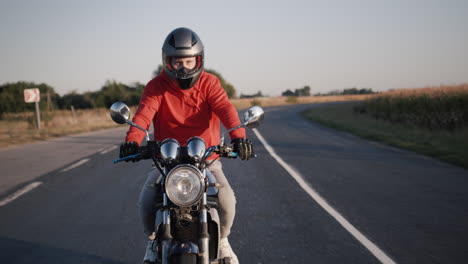 a young man on a motorbike rides along the picturesque fields 3