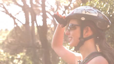 Smiling-woman-biking-through-a-forest-