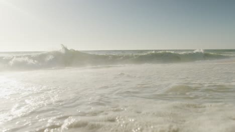 cielo azul y mar con olas en una playa vacía y soleada