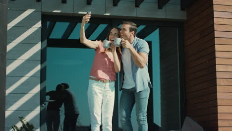 man and woman drinking coffee and posing on camera