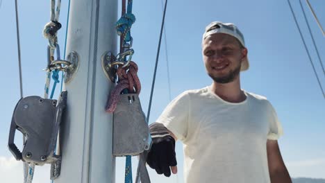 sailor working on the mast of a sailboat