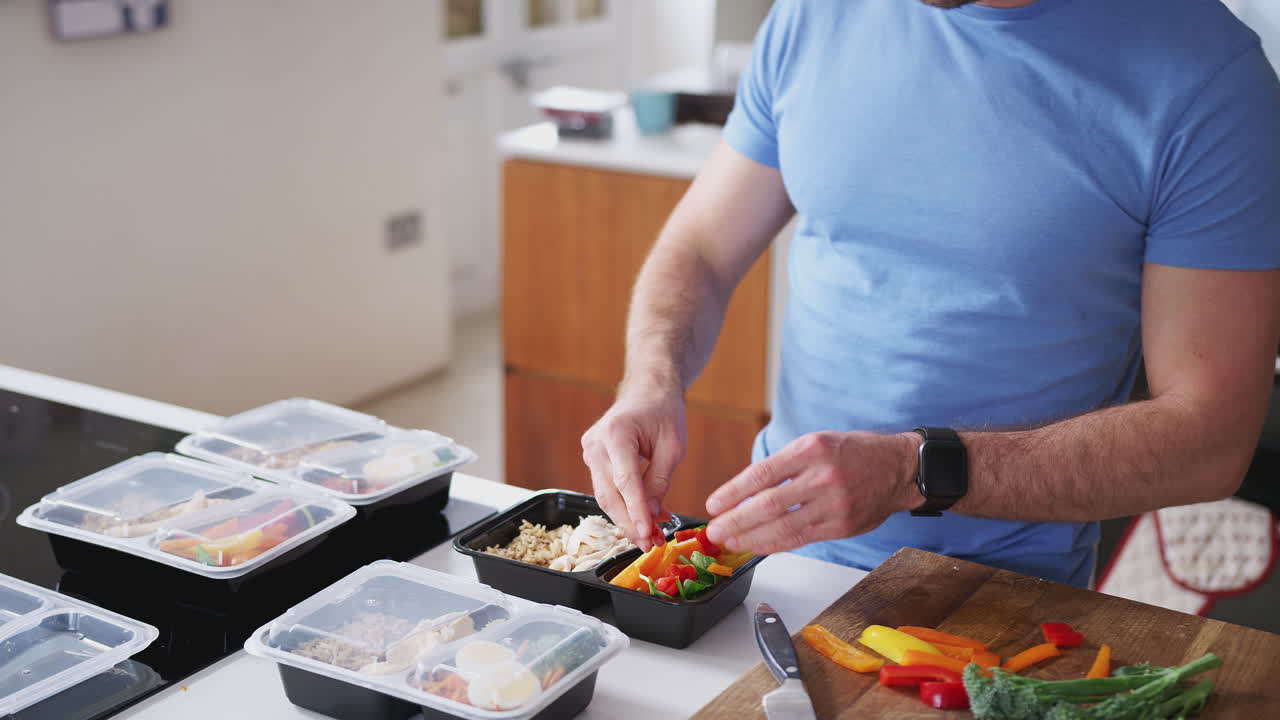 hombre vestido con ropa de fitness preparando un lote de comidas saludables en casa en la cocina